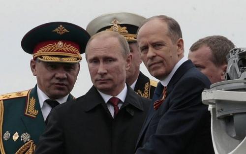 he featured photo shows  Russian President Vladimir Putin, center, flanked by Defense Minister Sergei Shoigu, left, and Federal Security Service Chief Alexander Bortnikov, right, arrives on a boat after inspecting battleships during a navy parade marking Victory Day in Sevastopol, Crimea. (AP Photo/Ivan Sekretarev, File) Friday, May 9, 2014